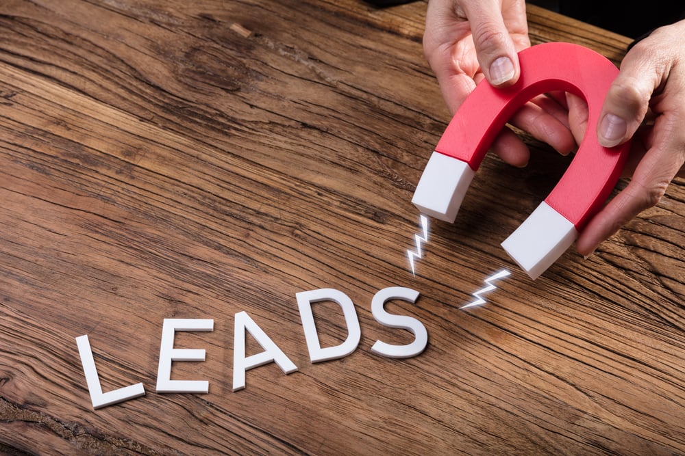 A magnet and the word "leads," property management lead generation concept. 