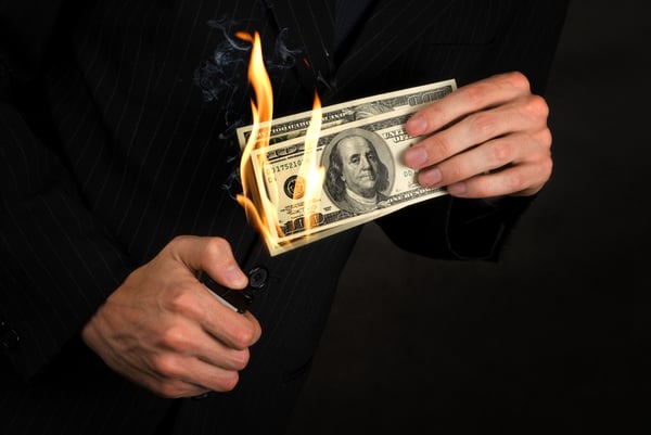 Flaming money in a hand