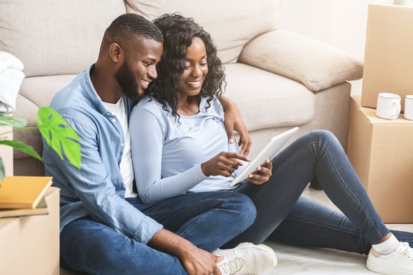 Happy couple using digital tablet for online shopping