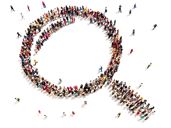 Large group of people in the shape of a magnifying glass