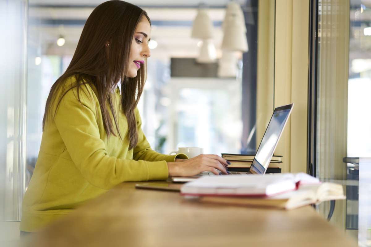 A young woman works at a computer, website content update process concept