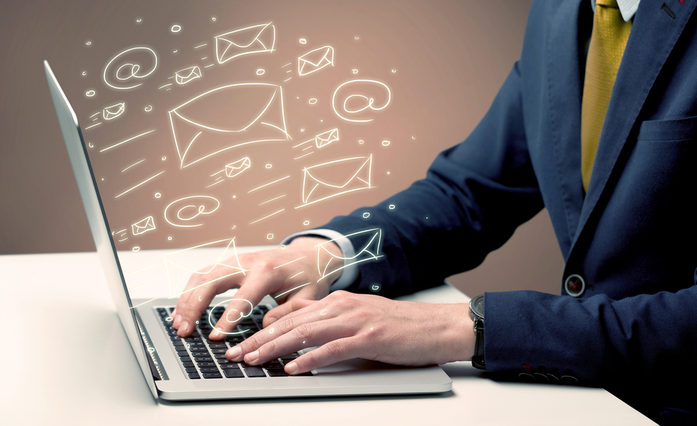 An office worker sending emails and communication with clients with the help of a portable laptop on desk concept