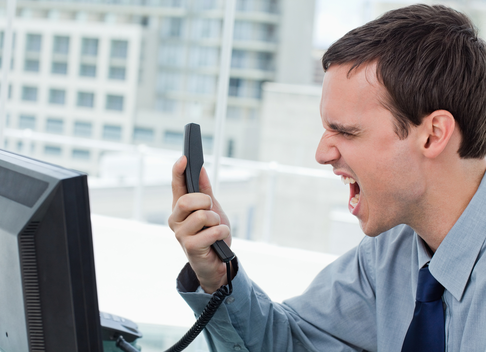Angry office worker on the phone in his office