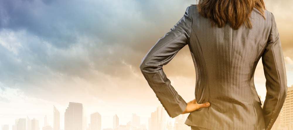 Back view of confident businesswoman with arm on waist