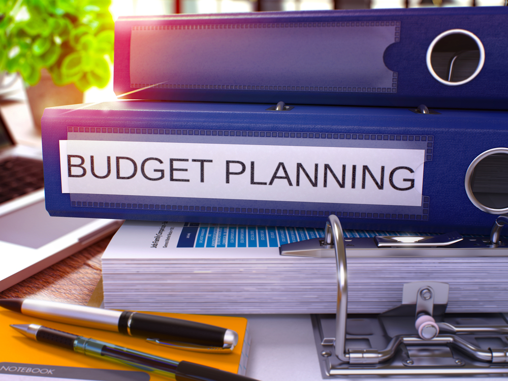 "Budget Planning" on a binder spine, creating a property management marketing plan concept. 