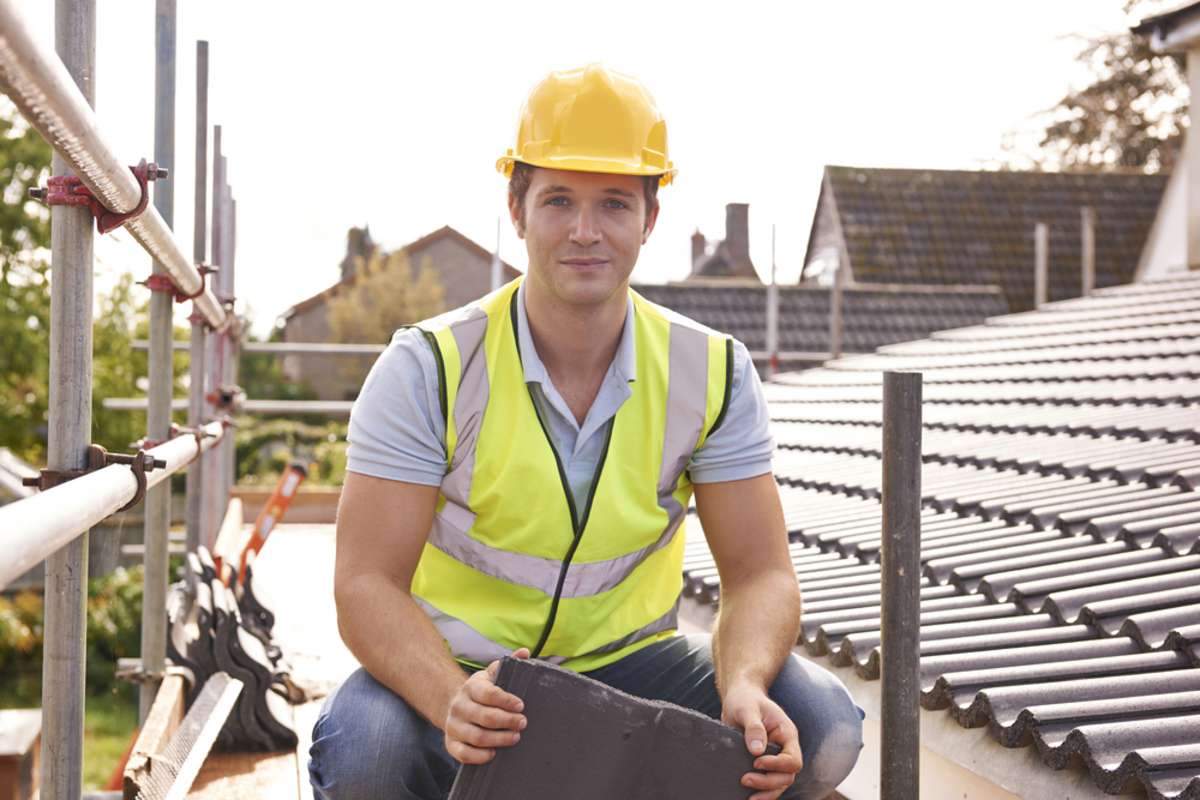 Builder Working On Roof Of New Building
