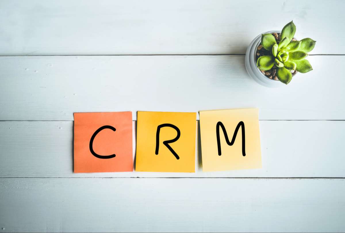 CRM word with paper note on white wood table backgrounds