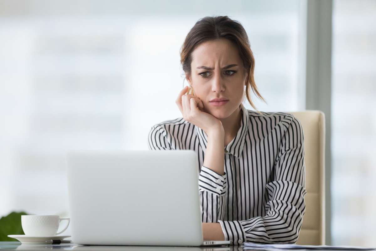 Confused businesswoman annoyed by online problem
