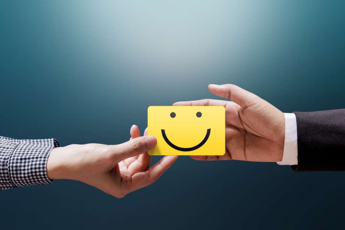 Customer Experience Concept, Happy Client Woman giving a Feedback with Happy Smiley Face Card into a Hand of Businessman