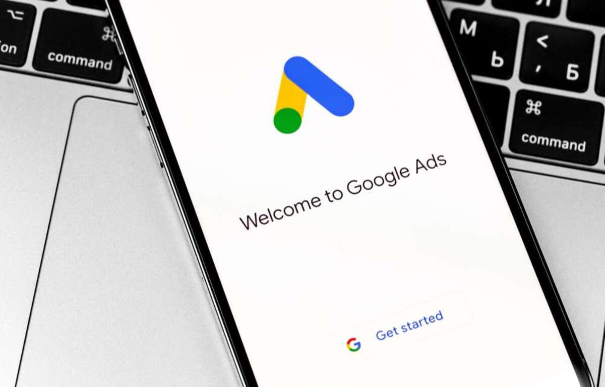 Google Ads (AdWords) logo app on black screen iPhone and MacBook closeup