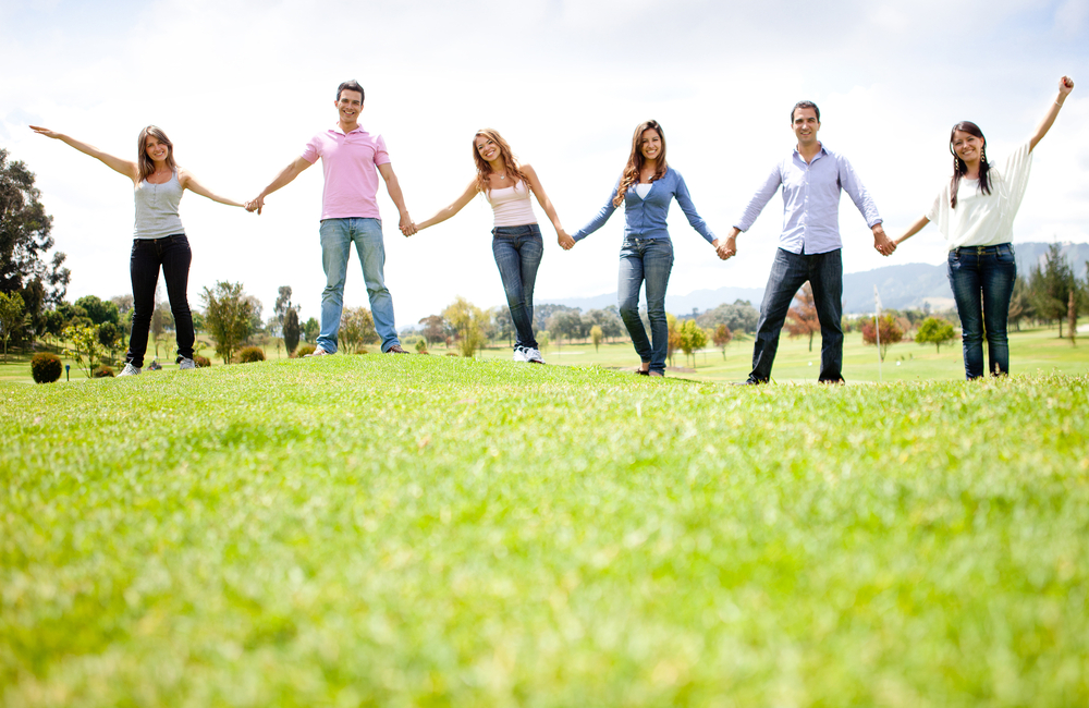Group of friends holding hands outdoors having fun