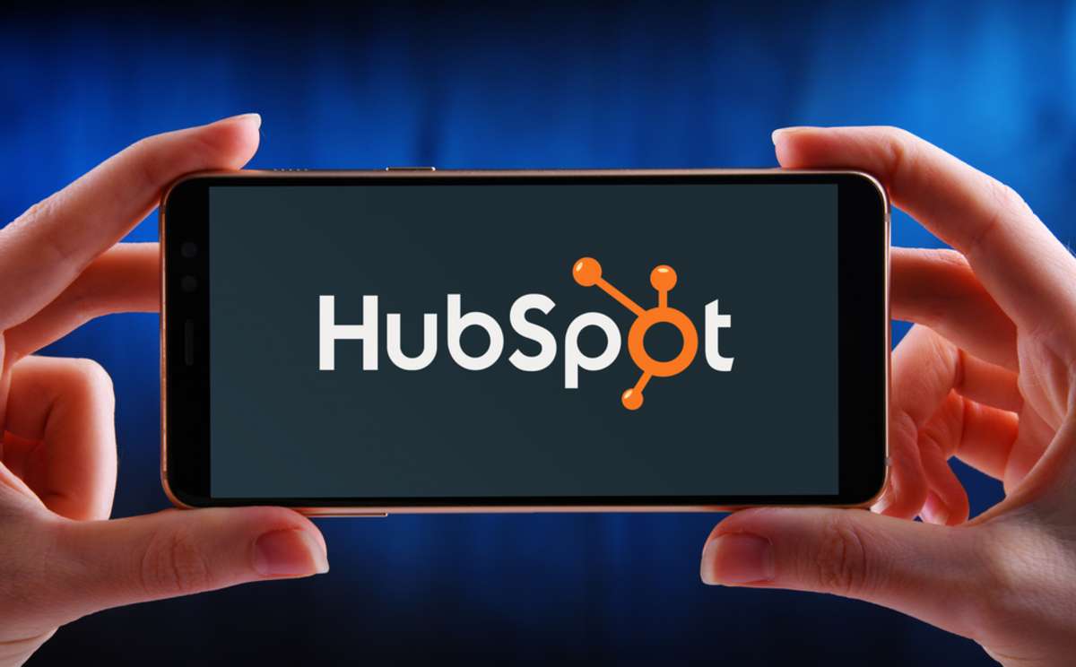 Hands holding smartphone displaying logo of HubSpot