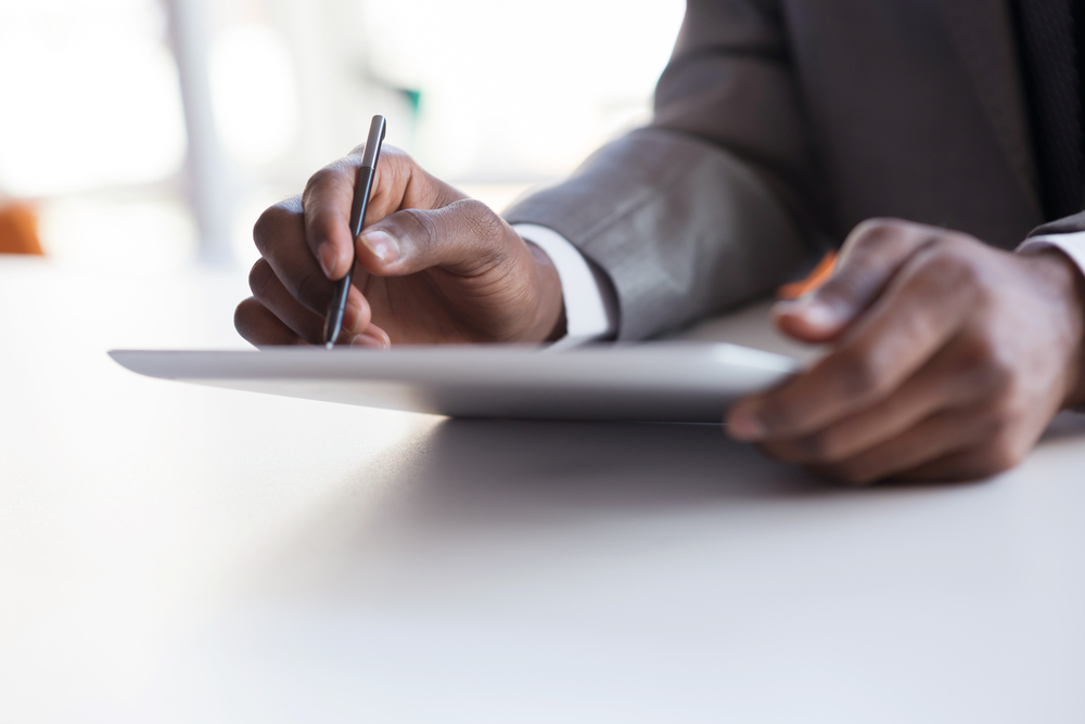 Man using tablet to view website, property management marketing concept. 