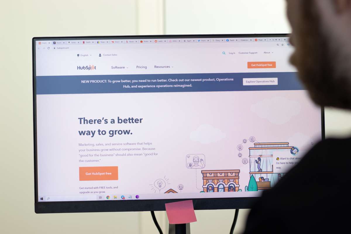 HubSpot website page on screen, man using service, Illustrative Editorial