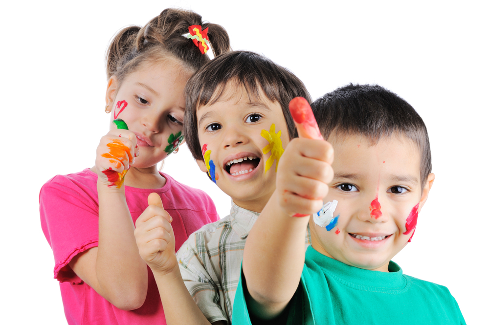 Messy children with paint on their hands and faces with thumbs up