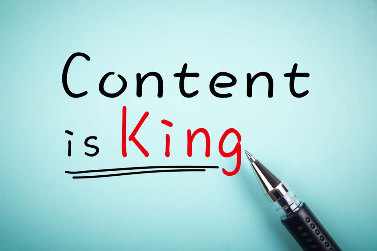 Text Content is King with underline and a ball pen aside