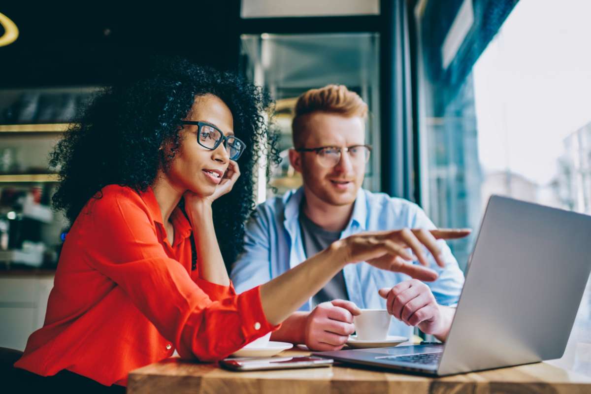 Two young professionals look at a laptop, SEO content audit concept