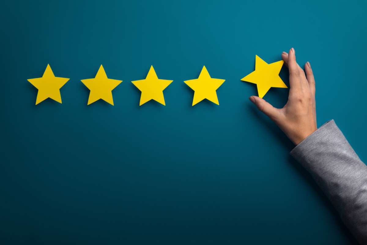 Woman hand giving five star rating on green background