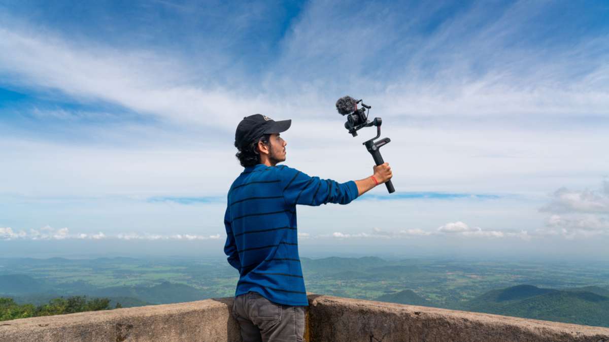 Young asian blogger or vlogger looking at camera and talking on video shooting with technology