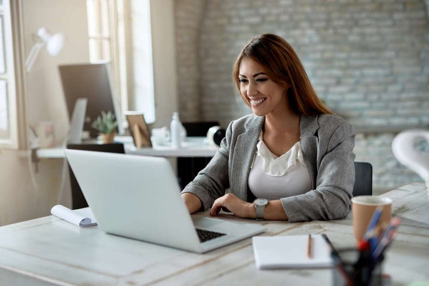 Young happy businesswoman using computer while working in the office