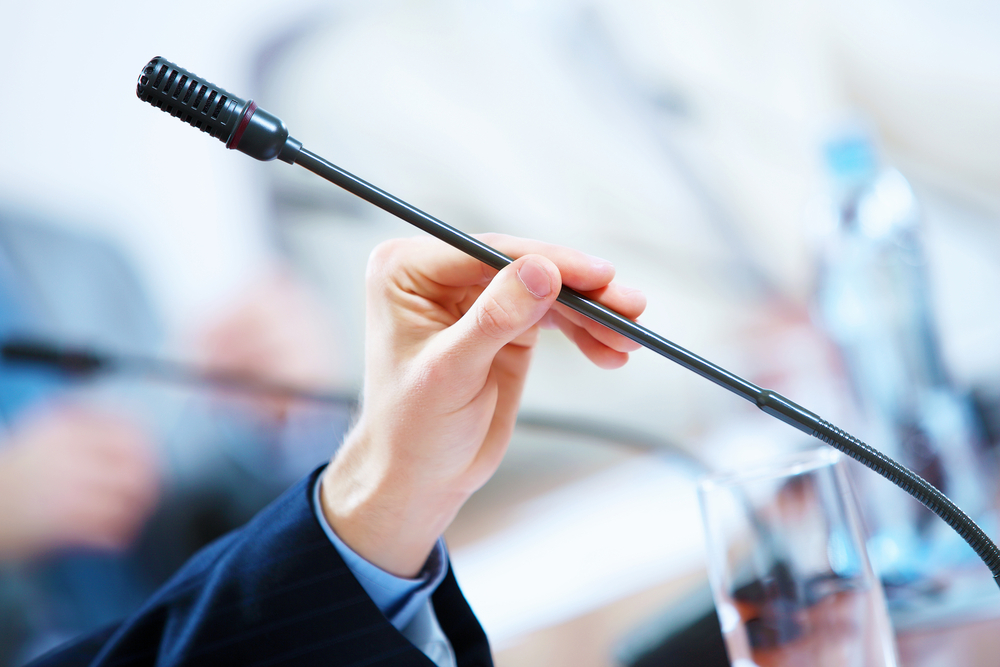 before a conference, the microphones in front of empty chairs.