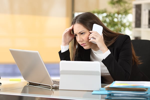 Worried executive with multiple devices