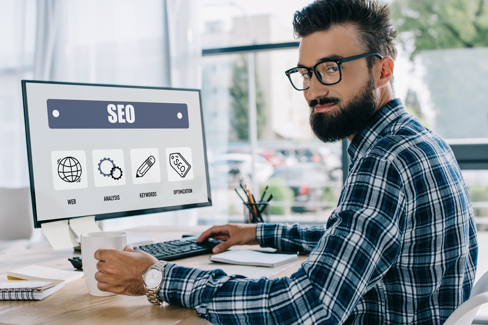 A man with SEO on a computer screen, SEO content concept.