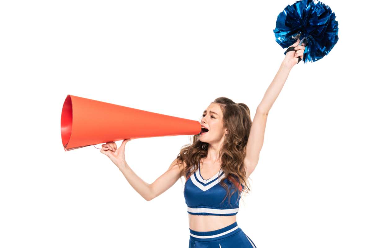 cheerleader girl in blue uniform with pompom using orange megaphone isolated on white