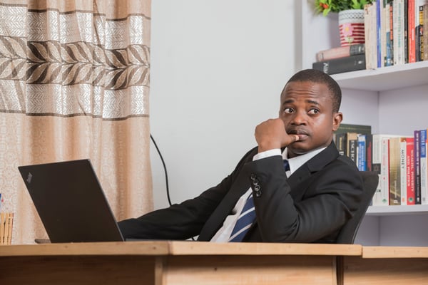 man in gray suit sitting on chair