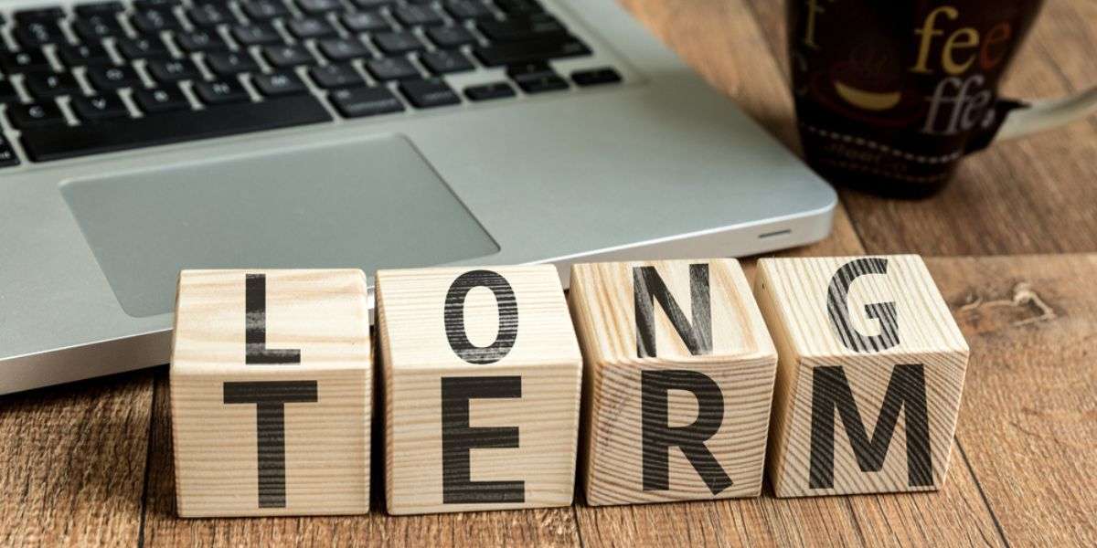 Long Term written on a wooden cube in a office desk