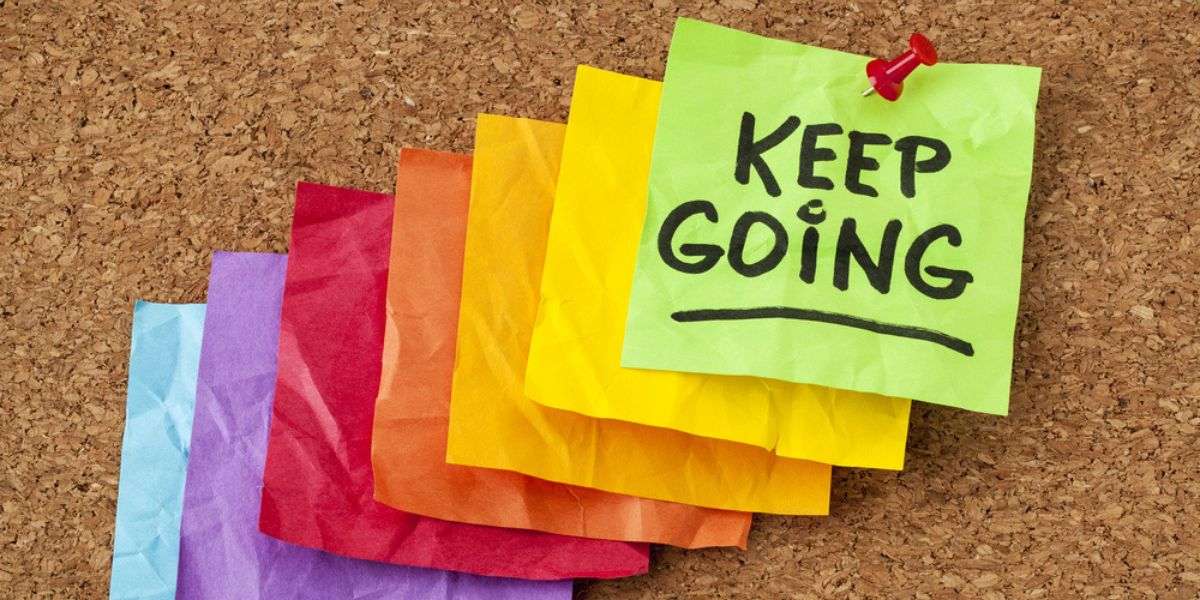 keep going - motivation or determination concept - handwriting on colorful sticky notes