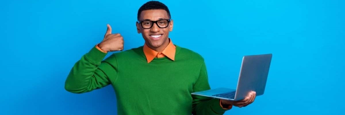 Portrait of optimistic good mood guy orange shirt under green pullover hold laptop showing thumb up