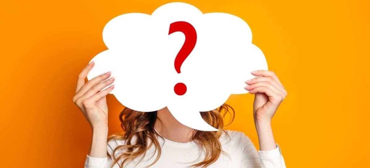 girl wearing white t-shirt holding paper card bubble with question mark isolated over orange background-1