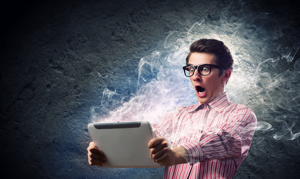 Young man looking shocked in tablet pc Young man looking shocked in tablet pc